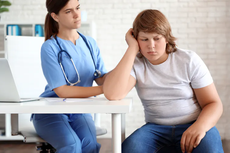 Unhappy boy being checked by a doctor
