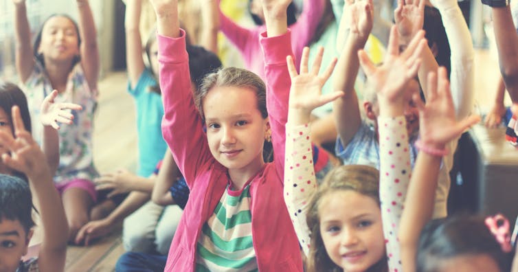 Children with their arms raised