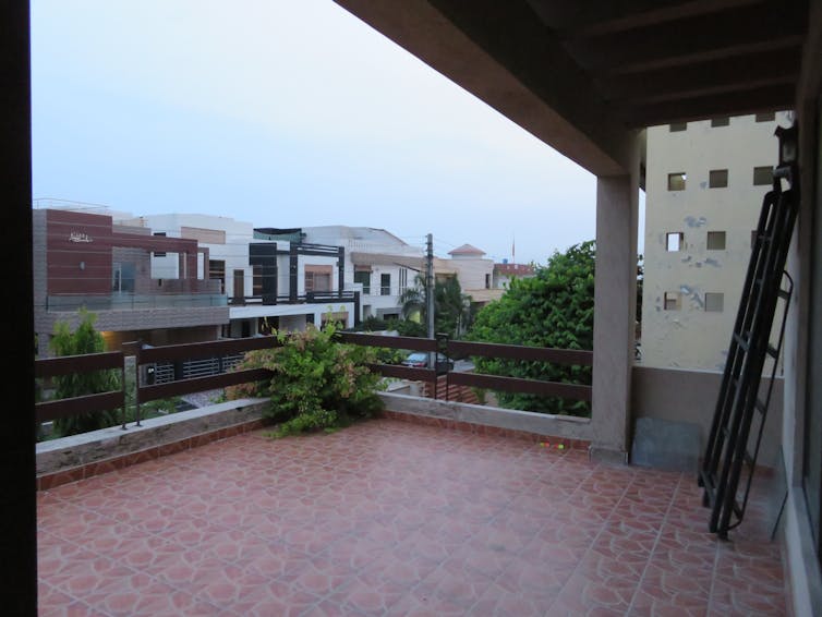 A balcony viewed from the left, with other houses facing it across the street