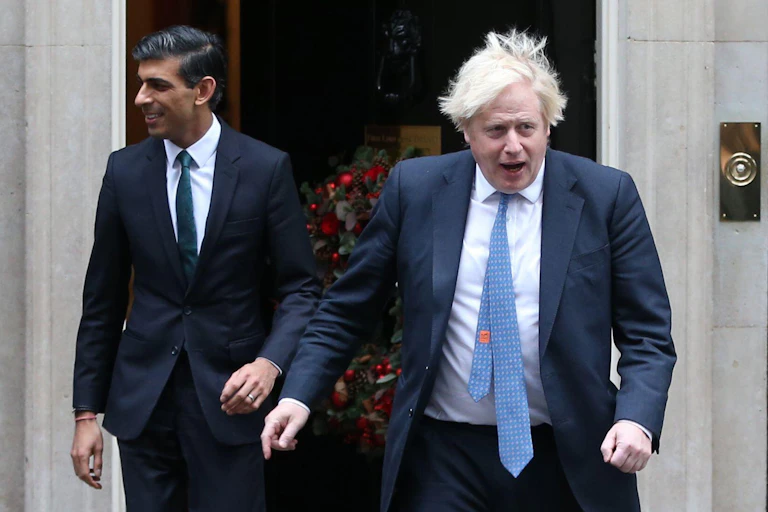 Rishi Sunak and Boris Johnson walking briskly out of Downing Street.
