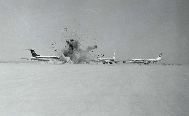 A plane on an airstrip explodes.