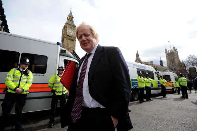 Boris Johnson in a suit smiling at the camera with Big Ben in the background.