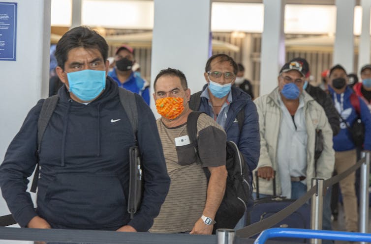 A line of people wearing face masks