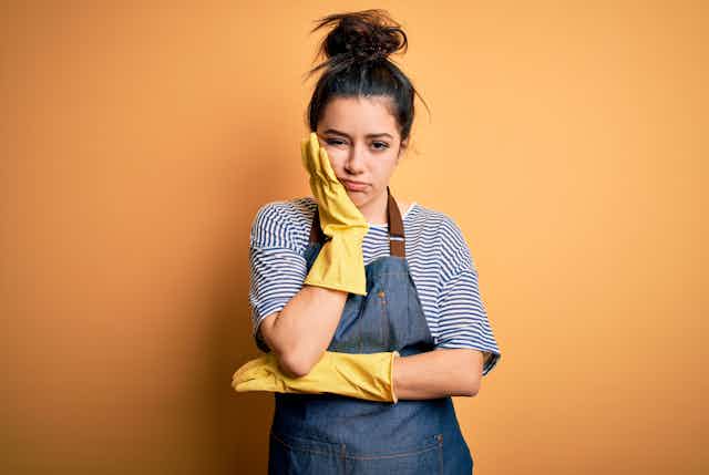 fed up young woman wearing yellow rubber gloves