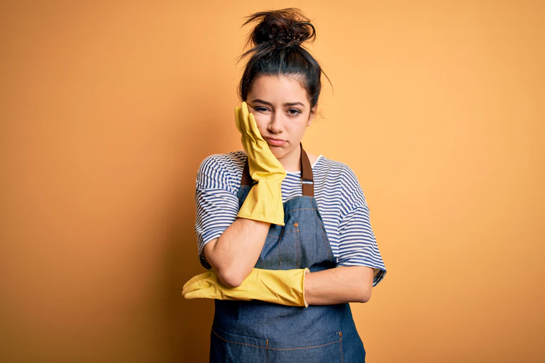 fed up young woman wearing yellow rubber gloves