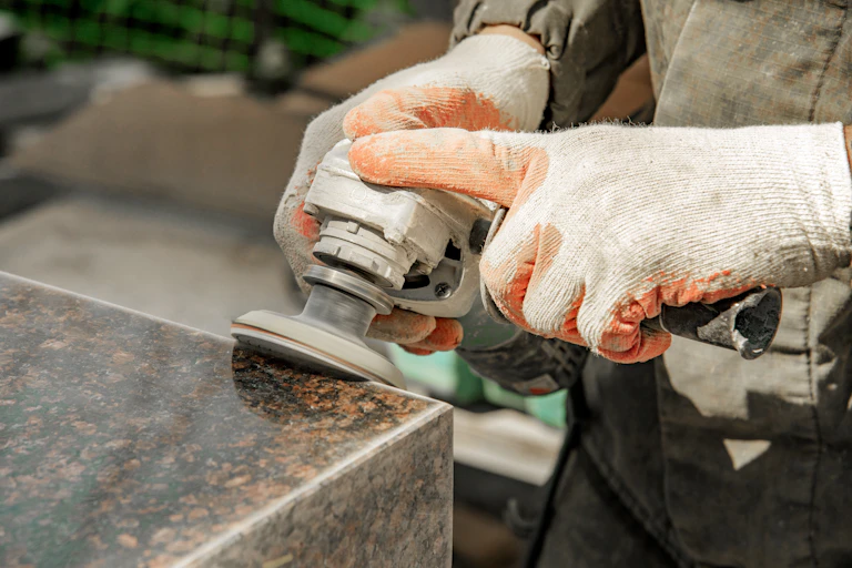 Tradesperson buffs artificial stone.