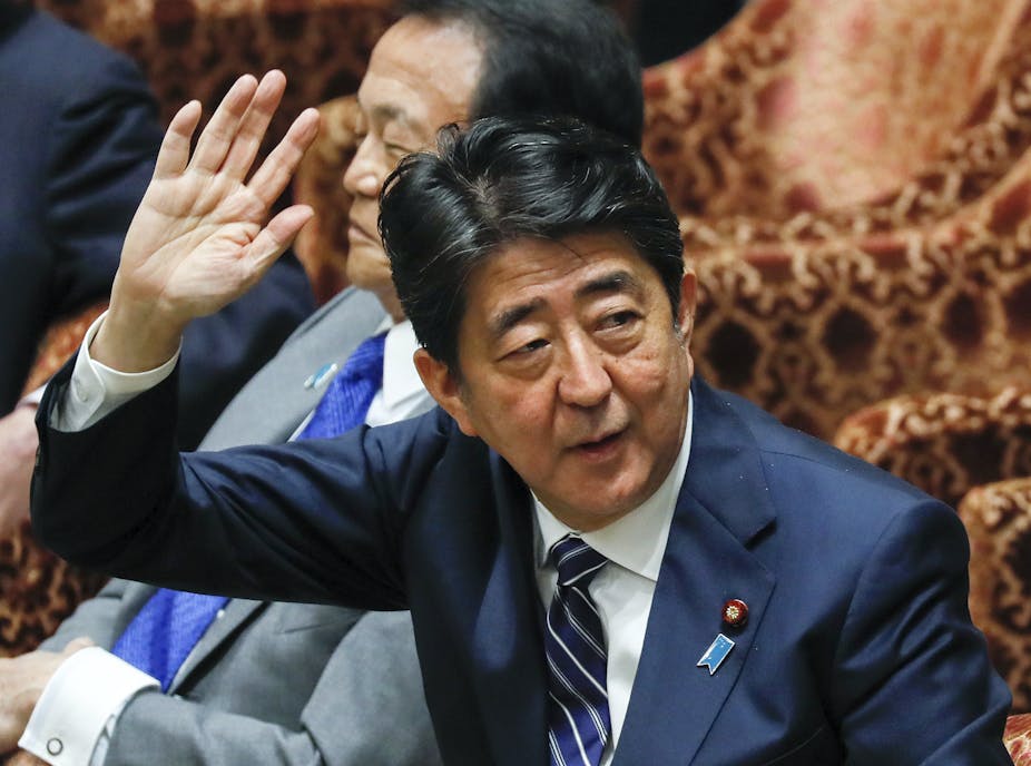 Japanese Prime Minister Shinzo Abe raises his arm as he speaks in the lower house, May 2018.