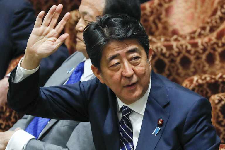 Japanese Prime Minister Shinzo Abe raises his arm as he speaks in the lower house, May 2018.
