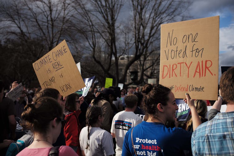 A group of people protesting with placards against poor climate change action.