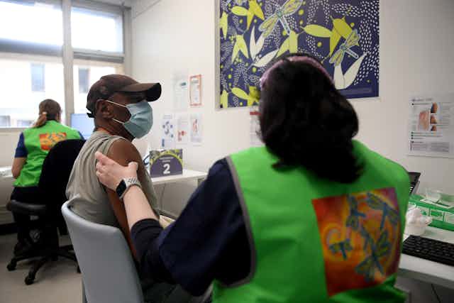 An Aboriginal person is getting their Covid vaccination in a clinic.