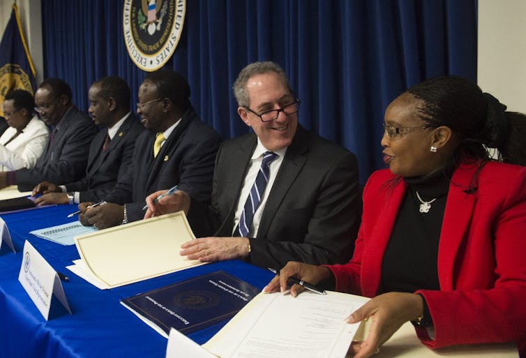 L’ambassadeur américain Michael Froman, assis devant un panneau aux côtés de représentants de la Communauté d’Afrique de l’Est