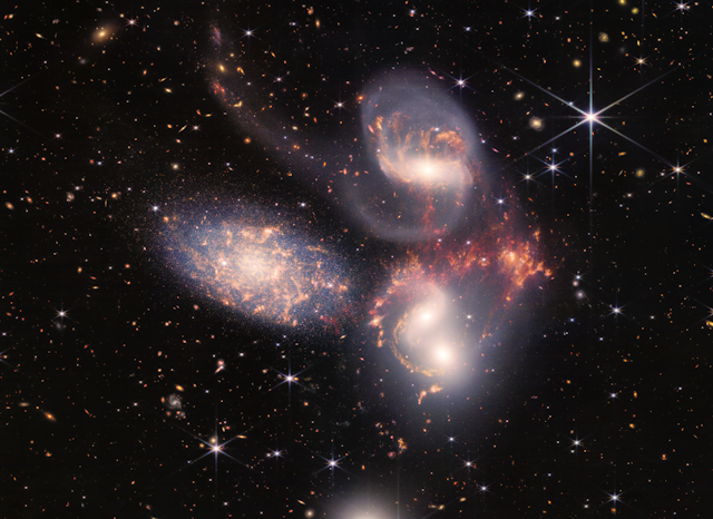 Five swirling galaxies against a starry background.