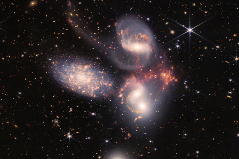 Five swirling galaxies against a starry background.