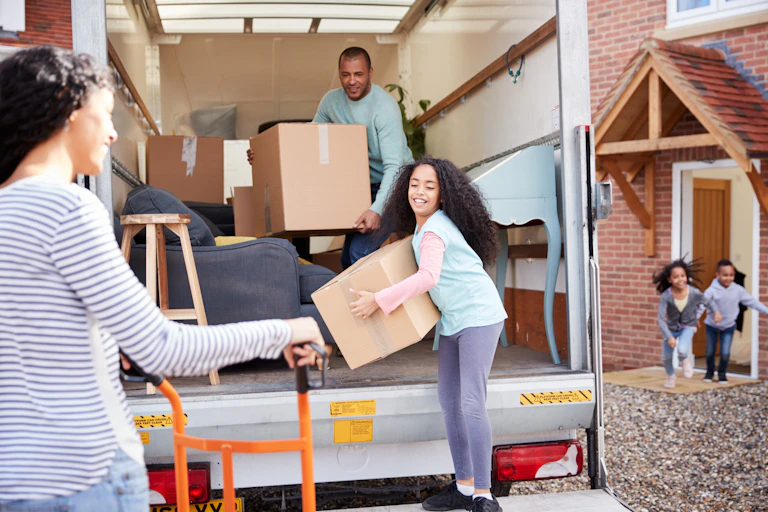 Family moving boxes out of the back of a truck