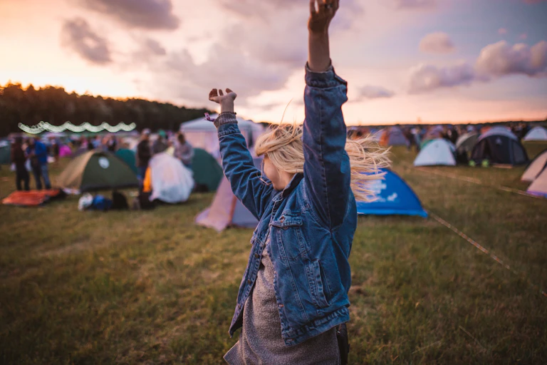 A girl dances in front of tents
