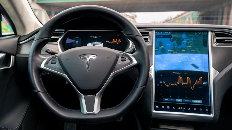 steering wheel and display screen in the interior of a vehicle