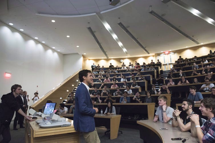 Justin Trudeau addresses a large group of university students in a tiered lecture hall