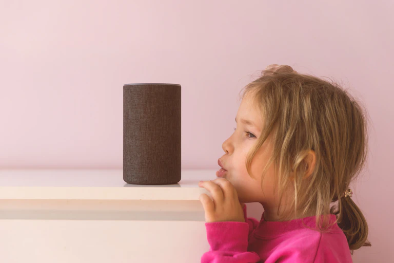 a young girl leans onto a shelf, about to speak to a speaker