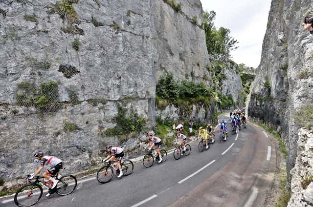 Cyclists going through narrow rocky gorge