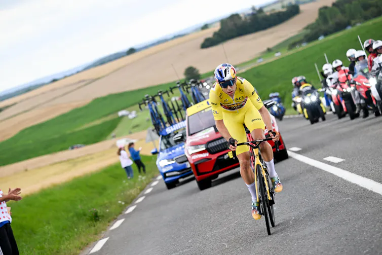 Man in yellow jersey cycles up hill