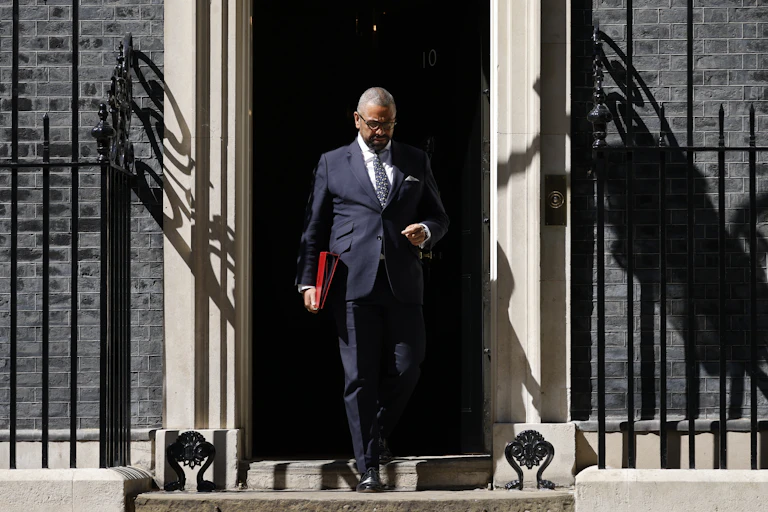 Man with red folder leaving building