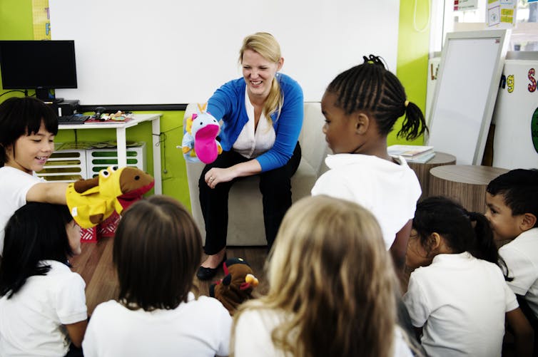 Teacher with puppet talking to class