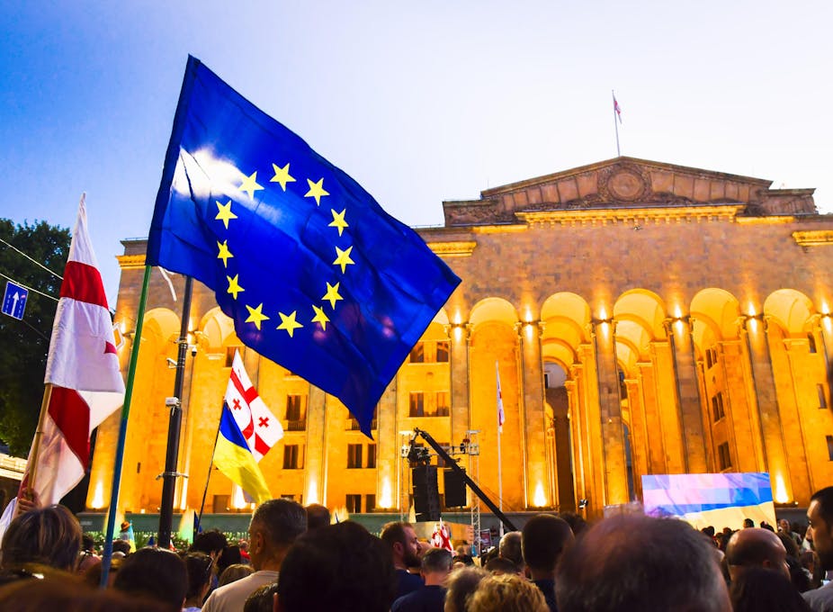 A large blue EU flag in front of a building.