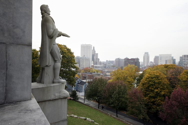 A statue of Roger Williams overlooking the skyline, in Providence, Rhode Island.