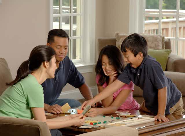 A family sits down to board game
