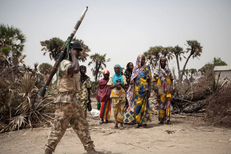 A Nigerian soldier, with a rocket propelled grenade patrols on the outskirt of the town of Damasak in North East Nigeria