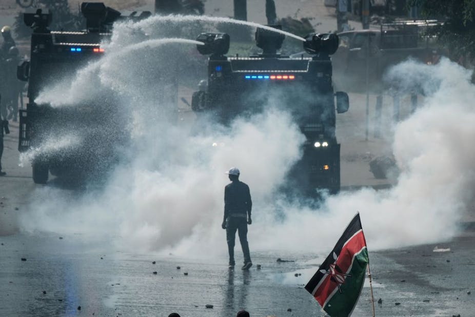 Man standing on a road clouded in teargas.