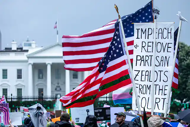"Impeach and remove partisan zealots from the court," reads one protester's sign in front of a large white building.