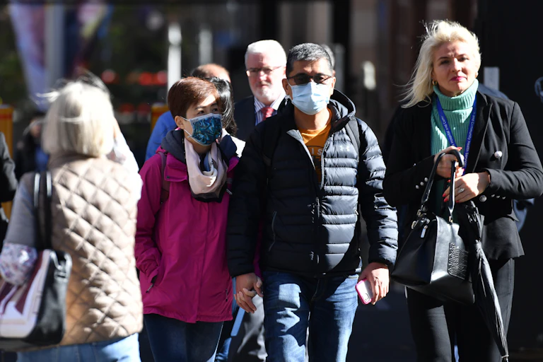 people on street, some wear masks