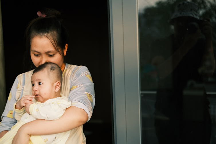 A woman holds a child close.