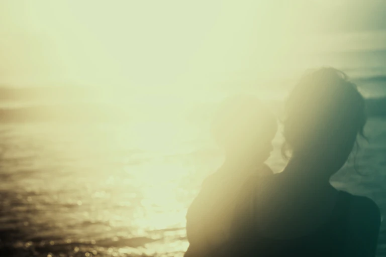 A woman and child silhouetted against the sun