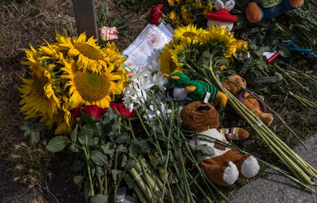 Bunches of sunflowers and a teddy bear have been left as a memorial the day after a Russian missile strike in downtown Vinnytsia, Ukraine, 15 July 2022.