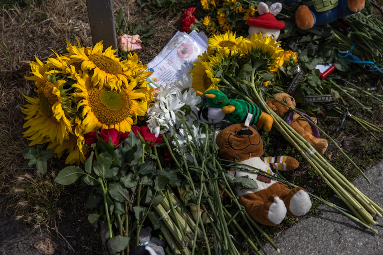 Bunches of sunflowers and a teddy bear have been left as a memorial the day after a Russian missile strike in downtown Vinnytsia, Ukraine, 15 July 2022.