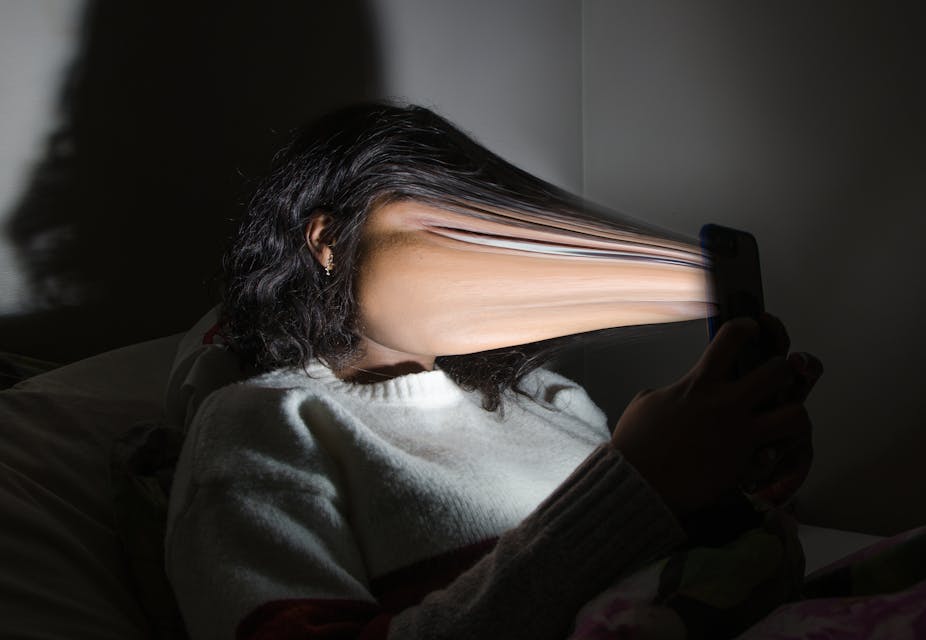 Rendering of woman's face being sucked into a smartphone screen.
