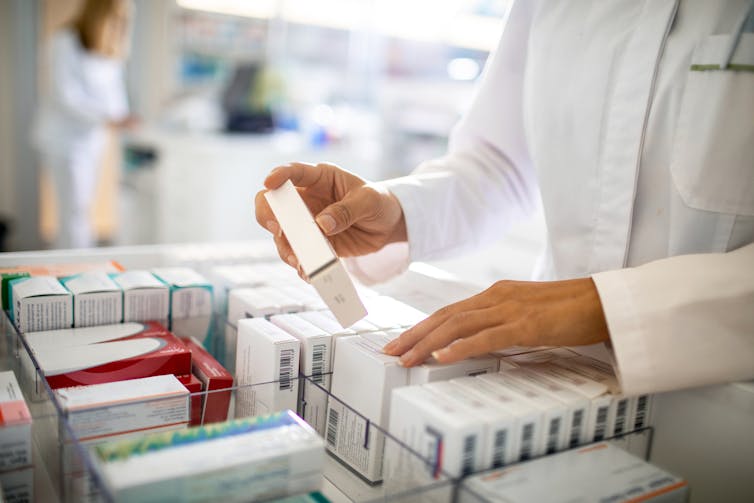 Pharmacist organizing medicine drawer