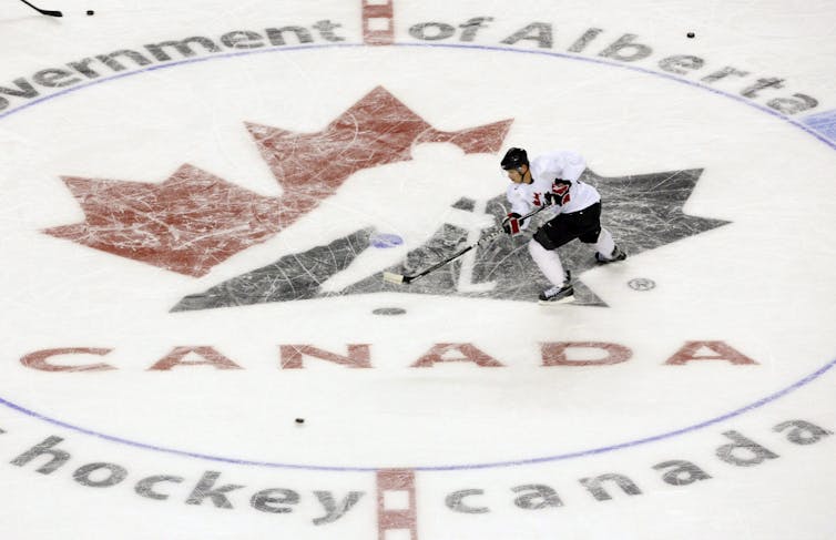 A man skates across a Hockey Canada logo