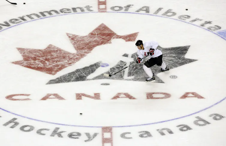 A man skates across a Hockey Canada logo