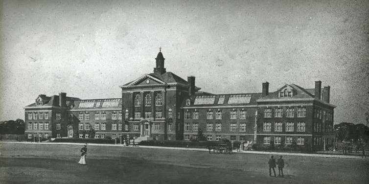 Black and white photo of a large brick high school building.