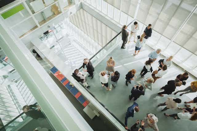a view from above of a group of people in business attire in the atrium of an office building