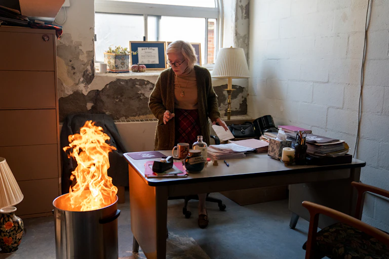 Holland Taylor as Professor Joan Hambling in The Chair, burning her student evaluations.