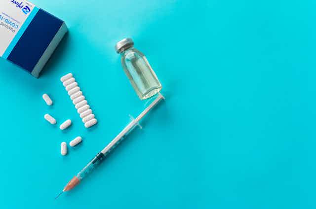 drug pills. vial and syringe on blue background