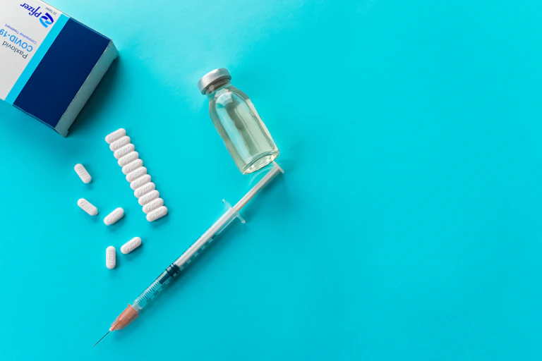 drug pills. vial and syringe on blue background