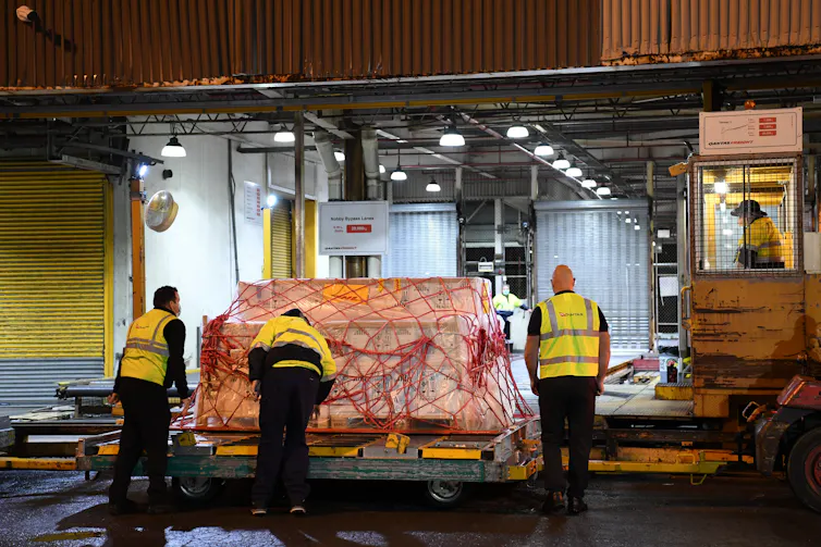 Men offloading a large crate of vaccines