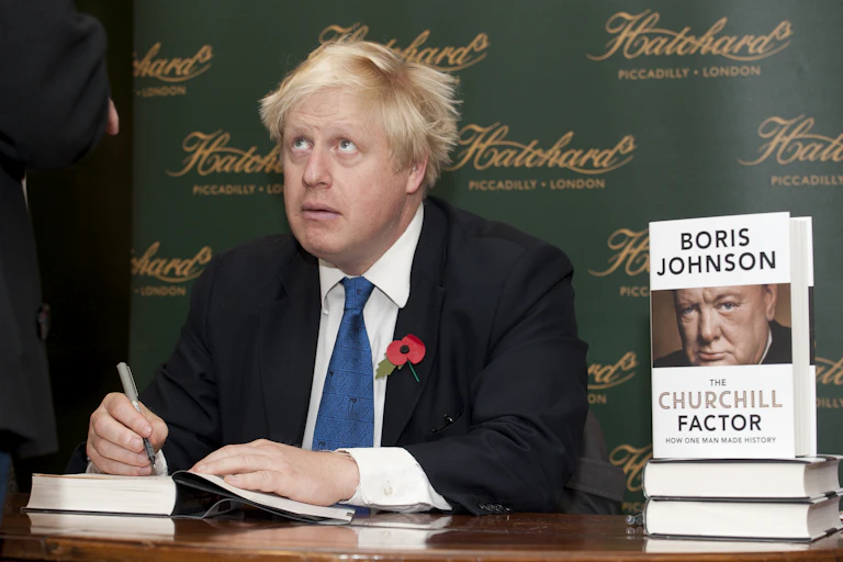 Man in suit writing in book