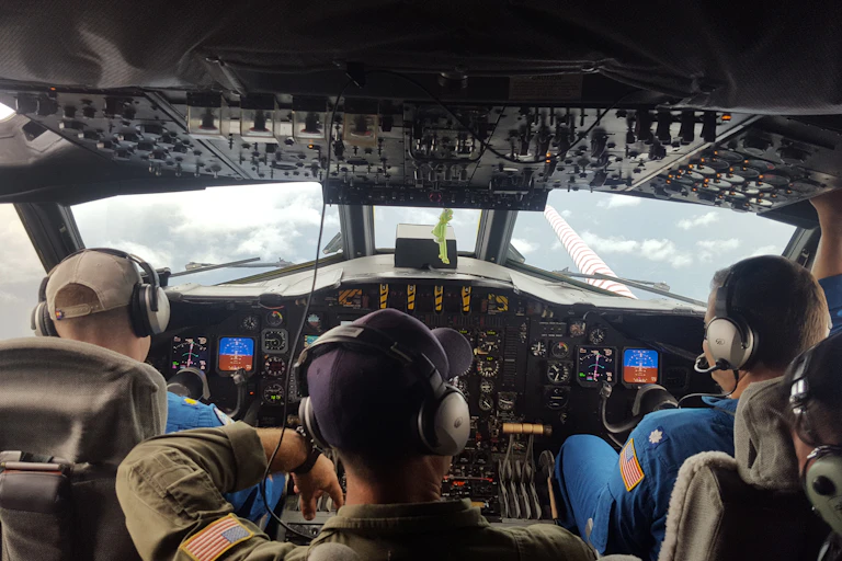 Pilots flying the plane and the view out the front window of the hurricane clouds.