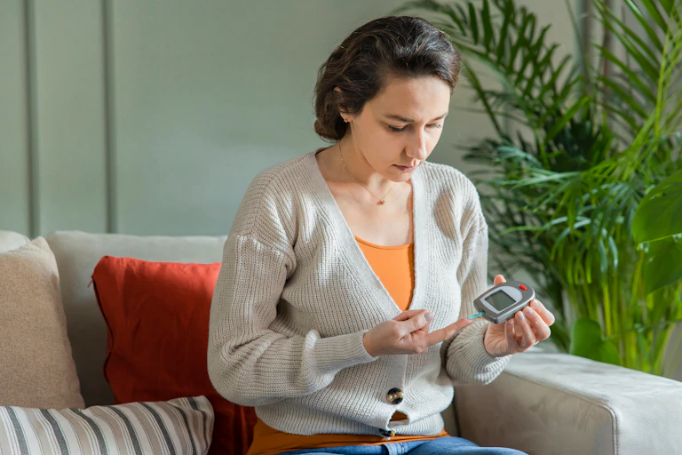 A woman measures her blood sugar levels by pricking her finger.